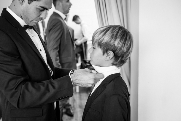 Groom Tying Bowtie for Page Boy | Credit: Lad & Lass