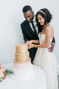 bride and groom with gold wedding cake | SouthBound Bride | Credit: Alexis June Weddings