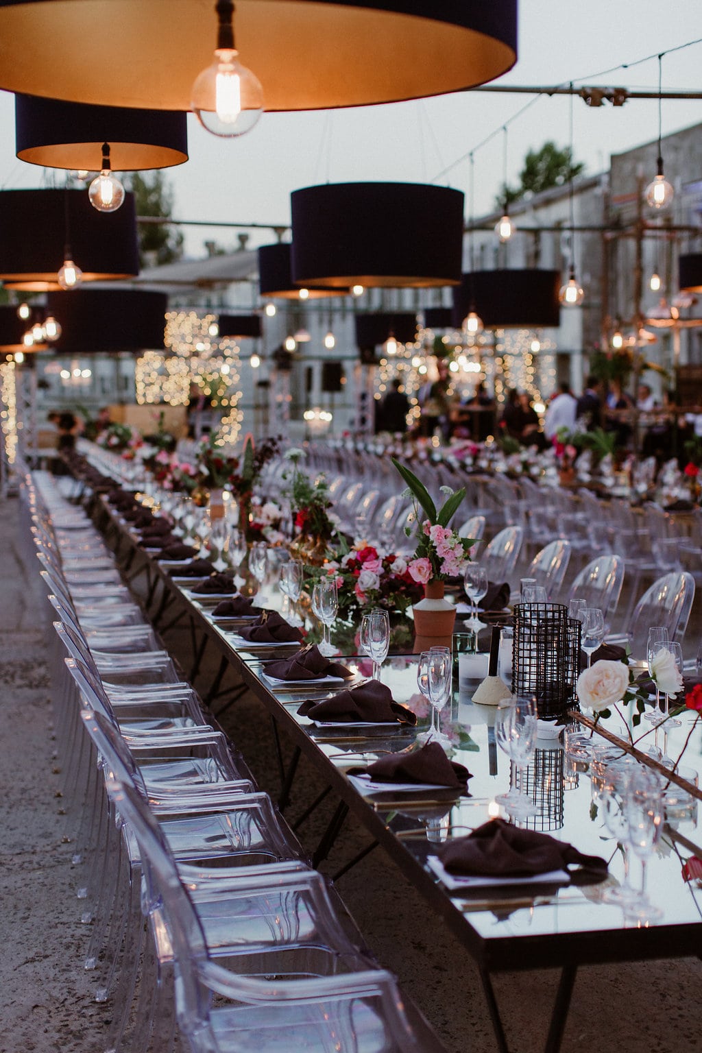 Long Glass Tables with Ghost Chairs and Hanging Lights | Image: Jenni Elizabeth